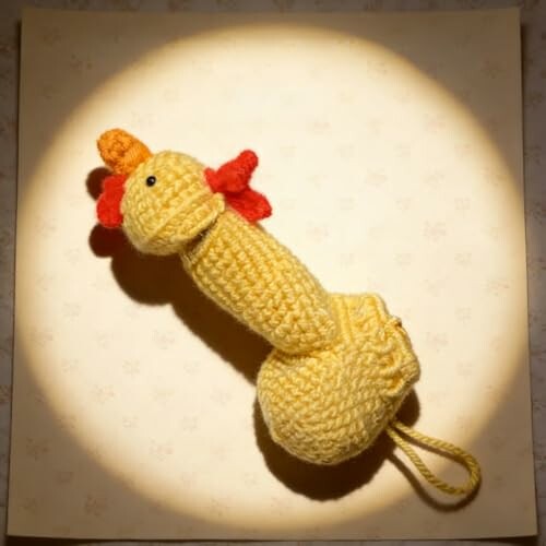 Crochet chicken-shaped toy in spotlight, highlighting its handmade and quirky design.