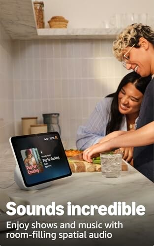 Two people in a kitchen using a smart display for cooking.